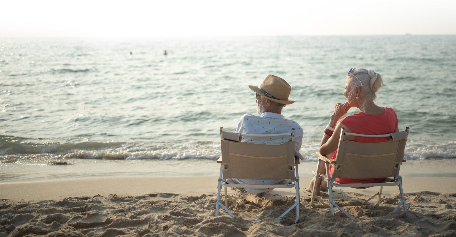 Elderly couple viewing a sunset on a beach